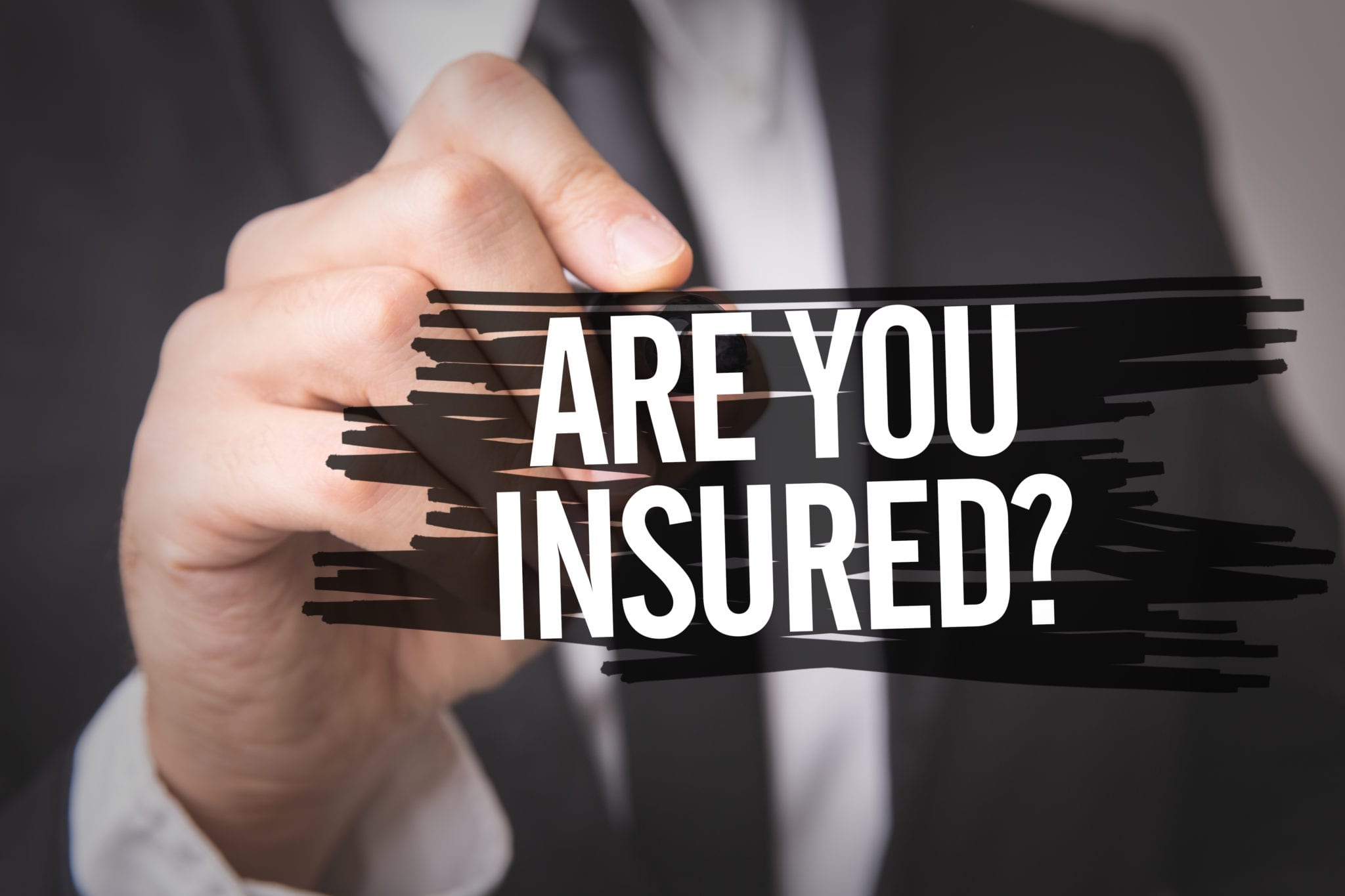 A man wearing a suit in the background with the words ARE YOU INSURED in the foreground.