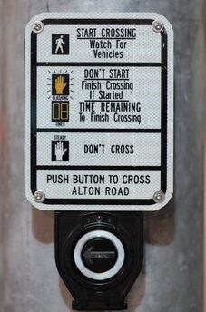 Crosswalk sign showing pedestrian signals with explanations for 'Start Crossing,' 'Flashing Start,' and 'Don’t Cross' indicators.